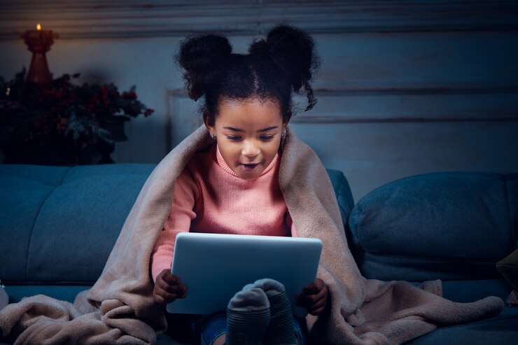 happy-african-american-little-girl-during-video-call-with-laptop-home-devices-looks-delighted_155003-20620
